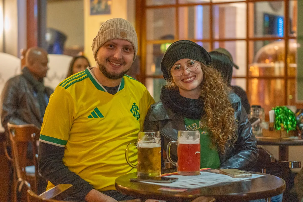 Visitantes brindando em uma mesa da Cervejaria Farol